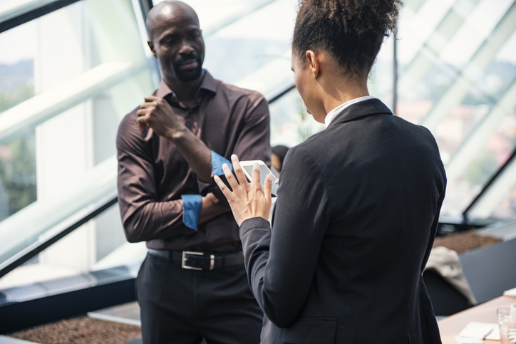 Excited happy colleagues looking at mobile phone screen
