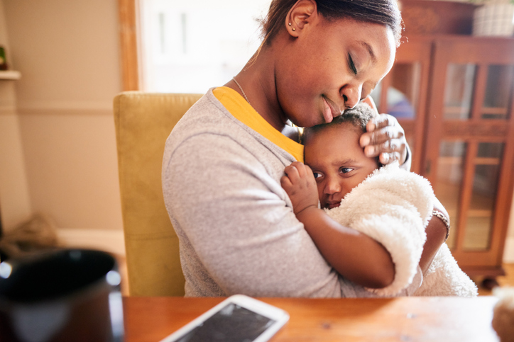 Caring young mother holding her little girl in her arms