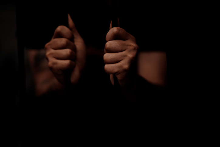 Selective focus on palm hand of Inmates being stuck in jail
