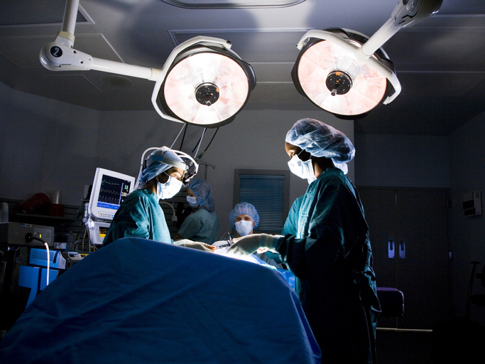Female nurse and surgeon in scrubs during surgery