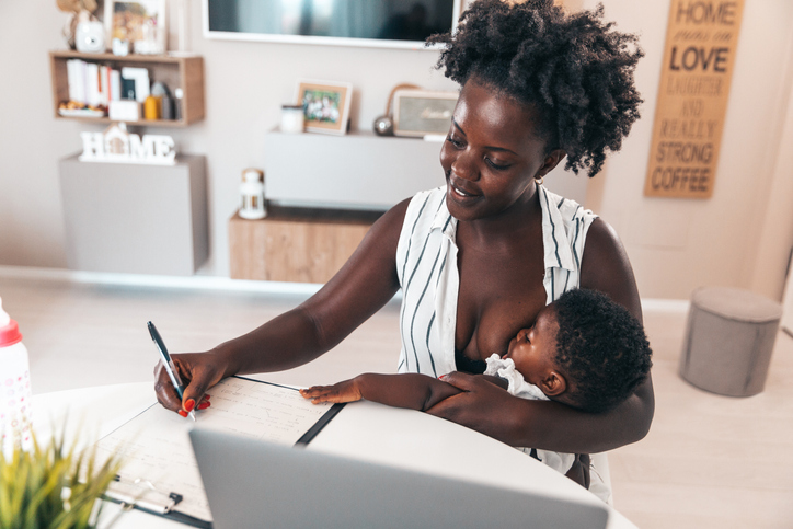 Business woman working at home and taking care of her two daughters