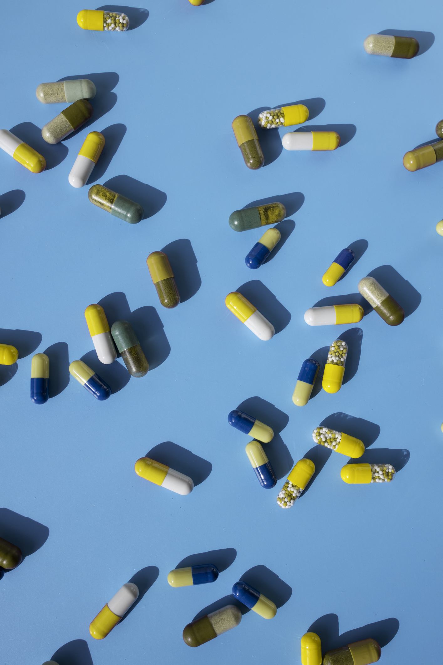 Top view of various pills and tablets on the blue background