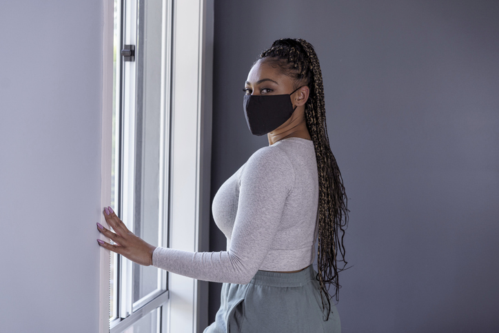 Woman in quarantine at home wearing cloth protective face mask