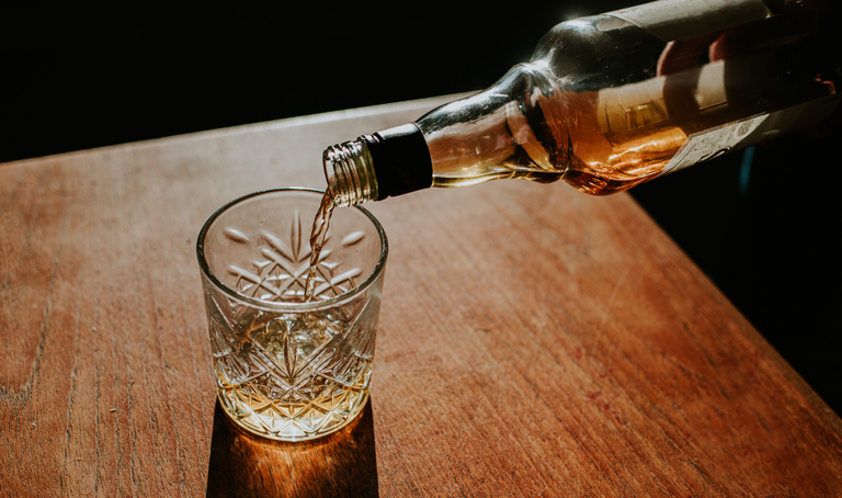 Whisky Pour from a bottle into a cut glass tumbler
