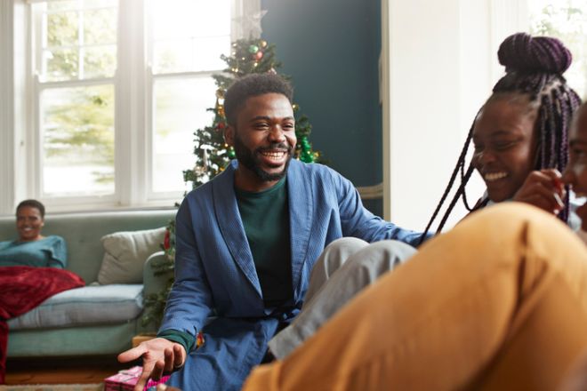 Smiling man looking at sisters playing at home