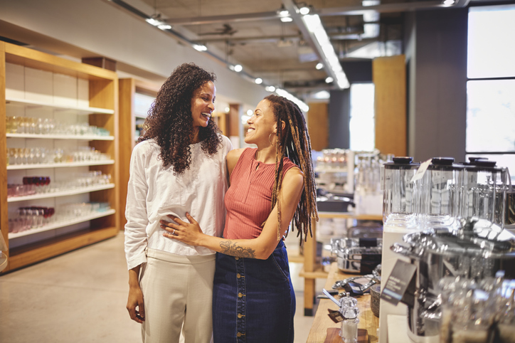 Happy lesbian couple shopping in home decor shop