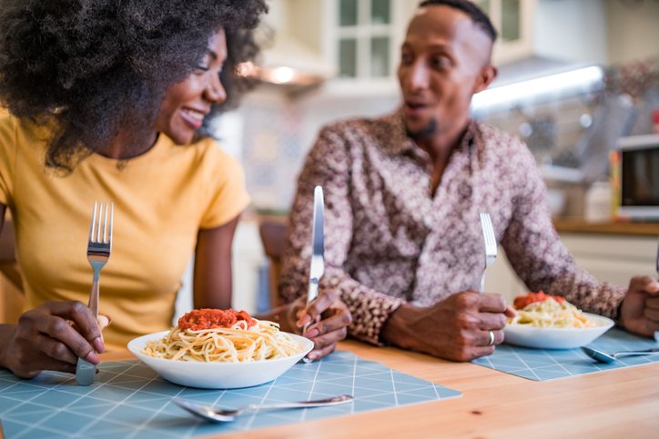 Couple eating spaghetti at home
