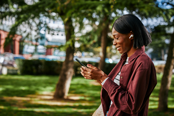 Woman with earphones using cellphone outdoor
