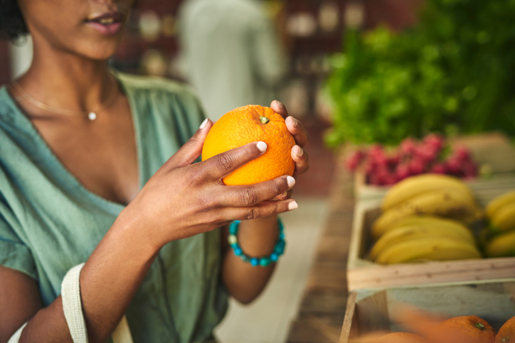 Shot of a young woman shopping for fresh produce at a farmer’s market