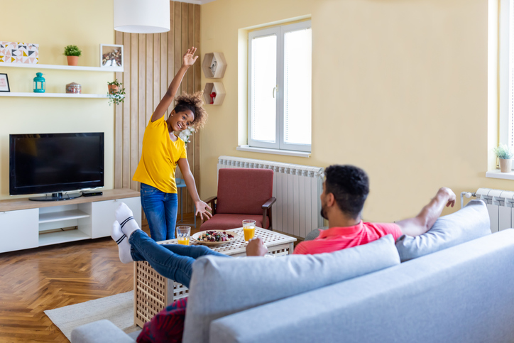 Black father and his daughter have fun and play charades together.