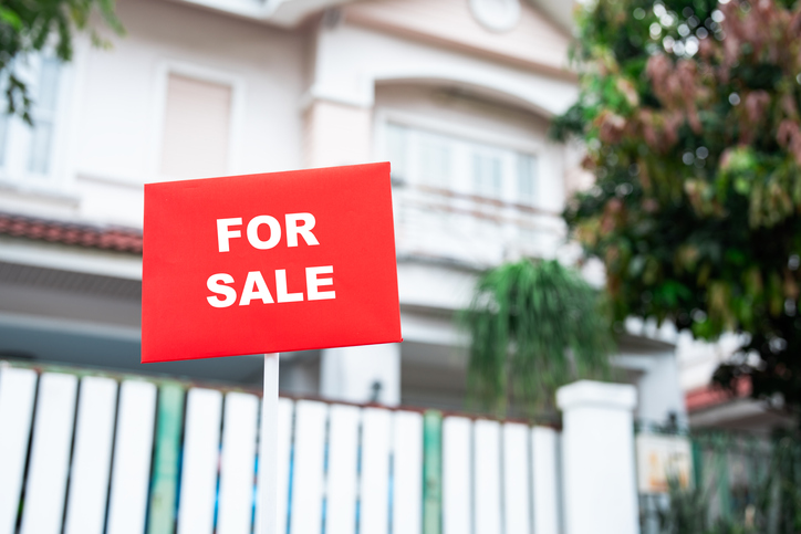 For sale sign in yard of house