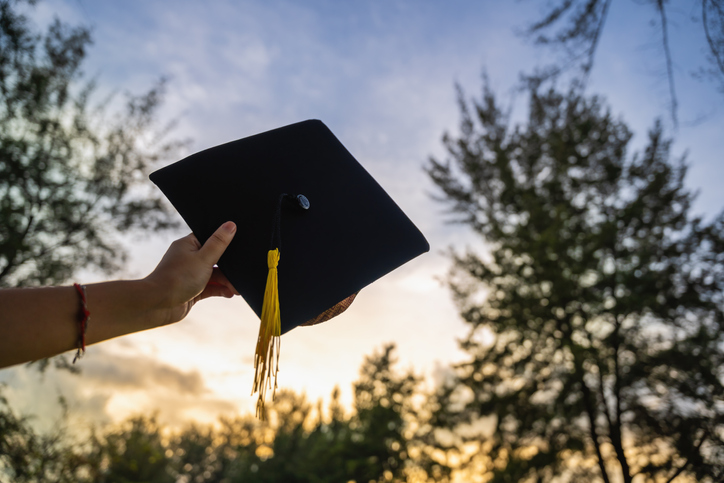 Hand Holding Graduation Cap