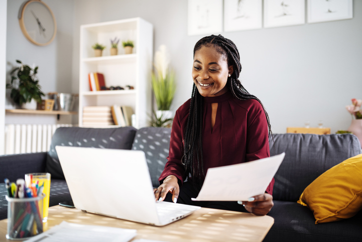 Woman of color analyzing utility bill at home