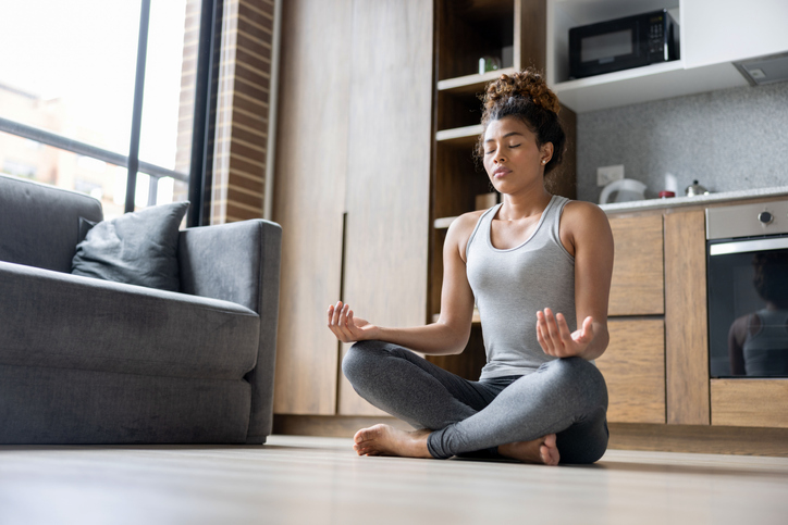 Young woman meditating at home