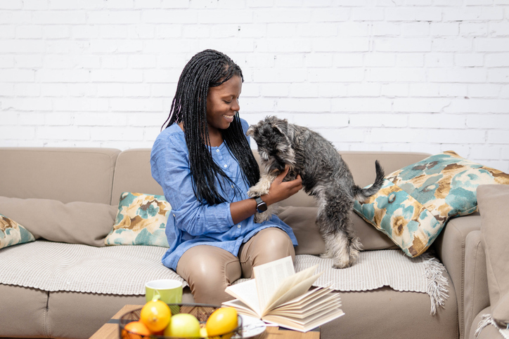 Woman playing with pet dog at home