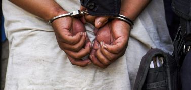Police handcuffed an alleged gang member before escorting...