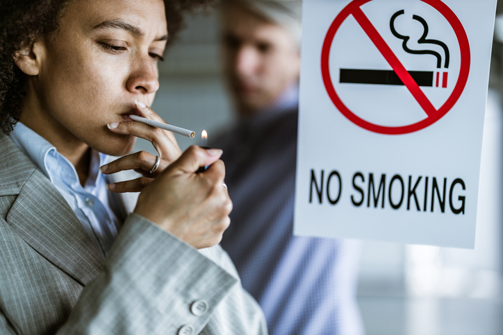 Black woman disobeying the no smoking sign!