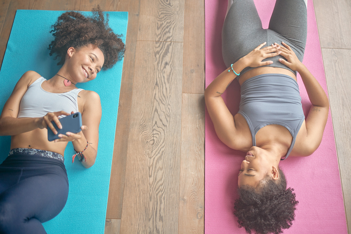 High angle shot of two young women chatting during a yoga class