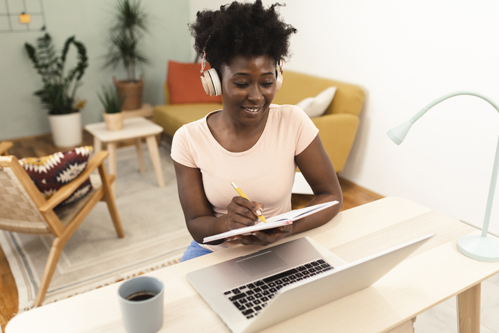 Portrait of a happy Afro woman planning her freelance business