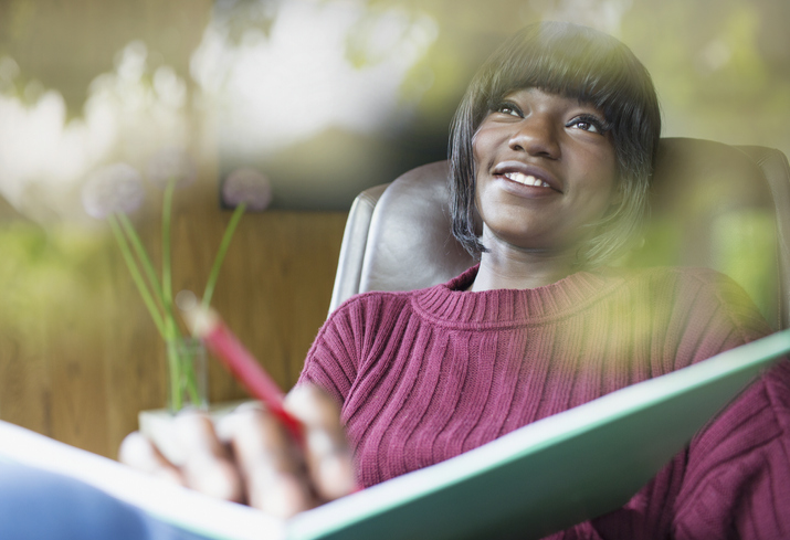 Happy young woman journaling