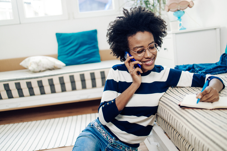 Happy African American woman working and talking on mobile phone