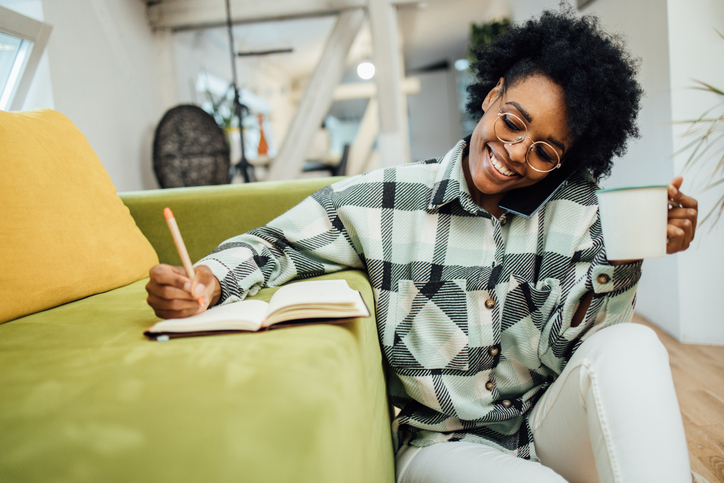 Portrait of African American woman enjoying coffee and writing her business plan