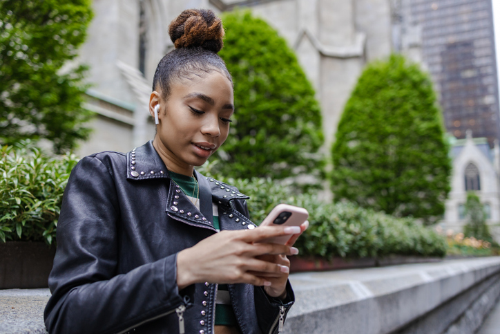 Young woman using phone on the street