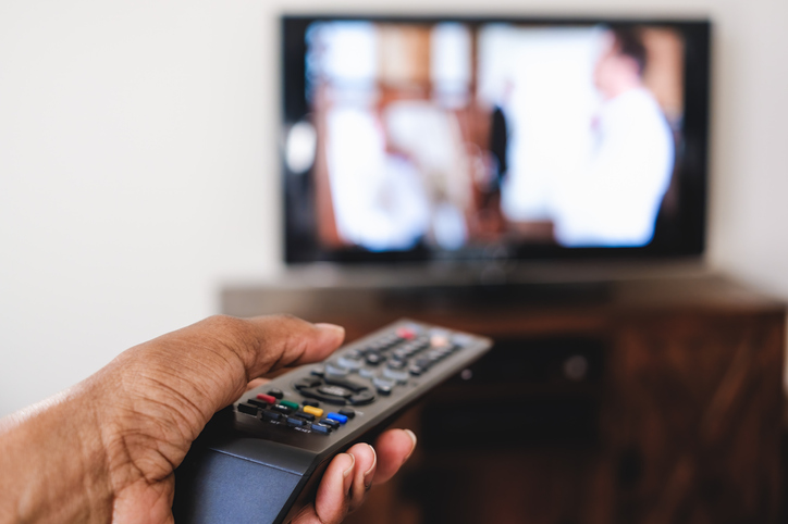 Woman Points Remote Control at TV
