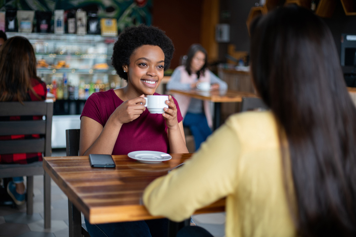 Happy friends having a cup of coffee together at a cafe