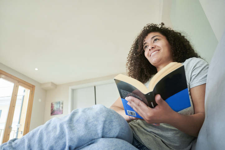 Woman on the sofa at home reading a book