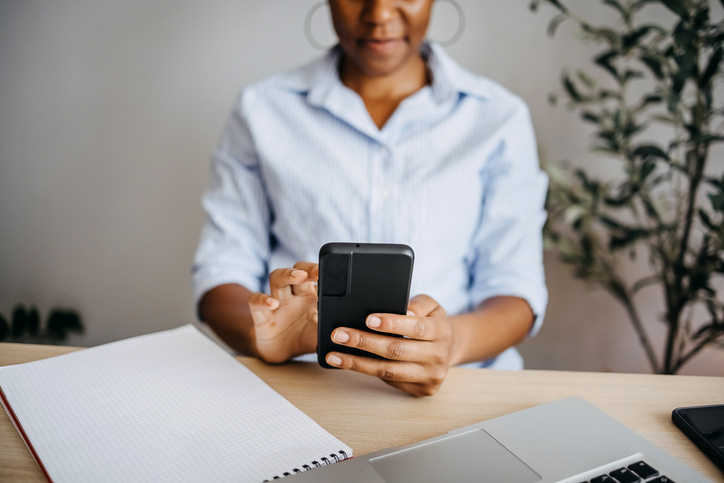 Young woman using smart phone at home office