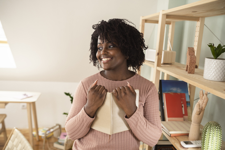 Portrait of a young African American woman holding her favorite novel