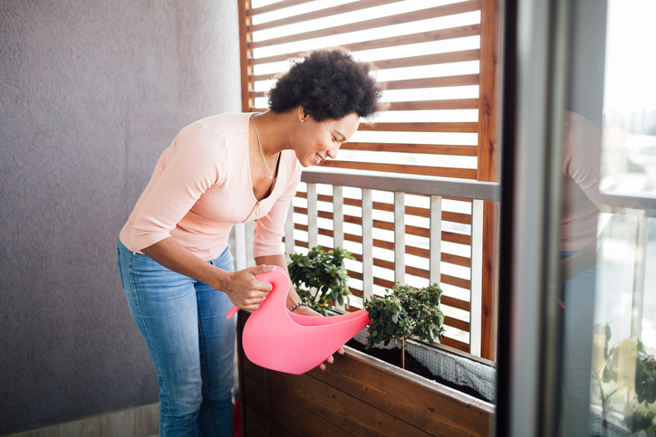 Middle aged woman watering her houseplants