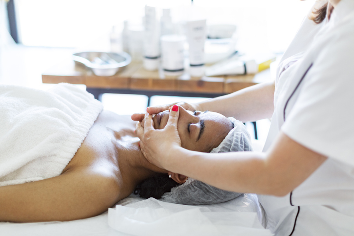 Cosmetologist making face massage at home