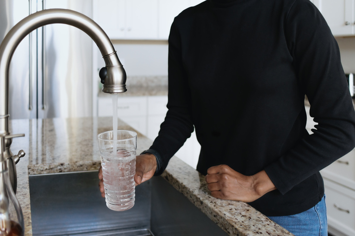 Woman Gets a Glass of Water From Kitchen Faucet