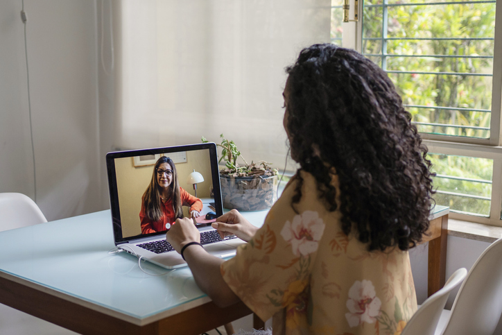 African Amican young woman talking to psychologist in video conference