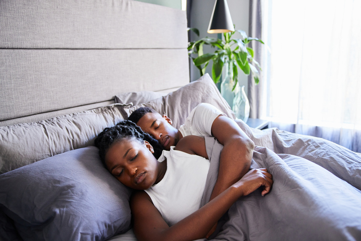 Young couple asleep in their bed at home in the morning