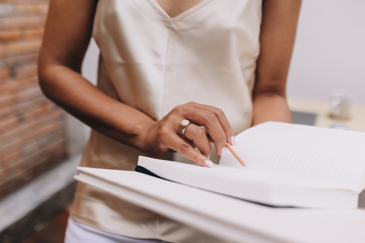 Midsection Of Woman Writing On A Notebook