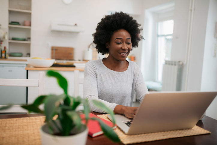 Happy young woman doing her taxes at home