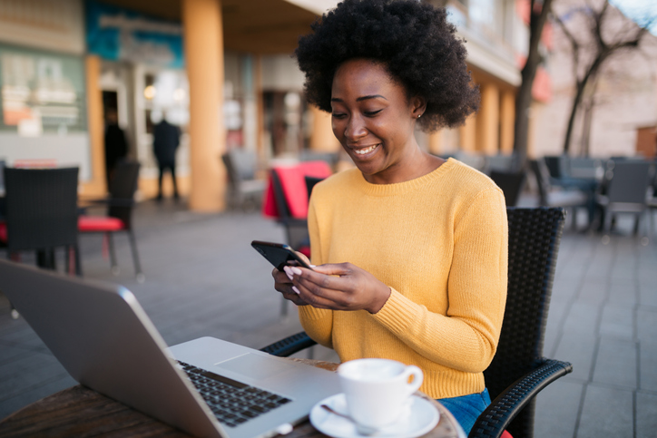 Happy young woman sitting in an outdoor coffee shop