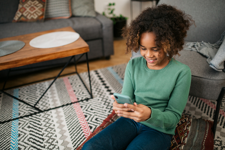 High angle view of a young African American girl using a smart phone