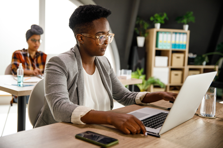 Selective focus shot of young businesswoman using laptop at her desk