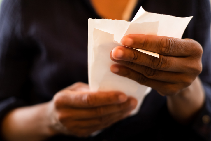 economy: black woman holding multiple retail receipts