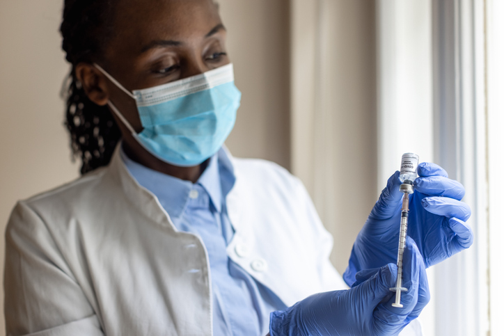 Black nurse preparing COVID-19 vaccine