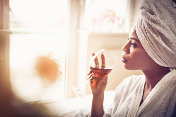 woman drinking wine in bed