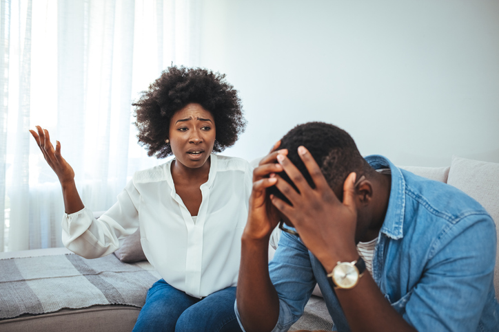 Emotional annoyed stressed couple sitting on couch, arguing at home facing financial infidelity