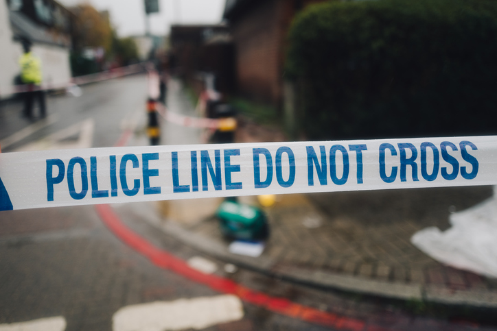 Police white and blue cordon tape separating the crime scene.