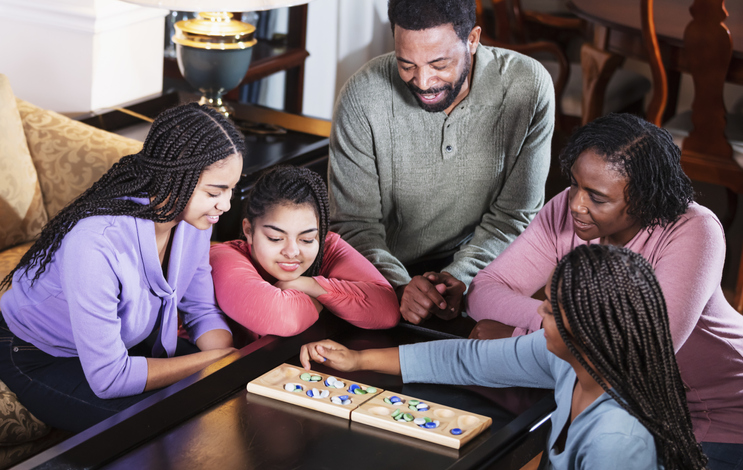 African-American family at home playing board game