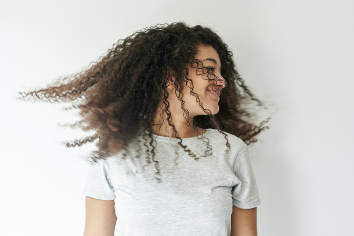 Portrait of woman tossing her curly hair
