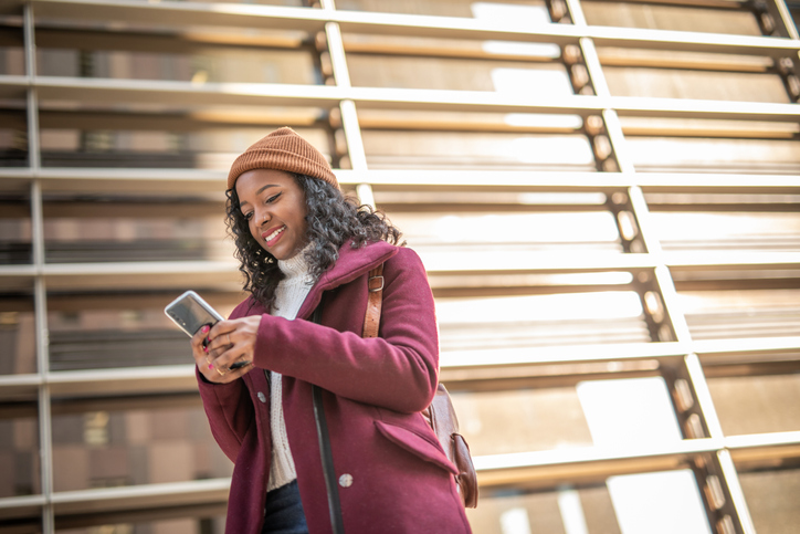 A woman, a young black woman, walks through the streets of Barcelona on a beautiful sunny winter day